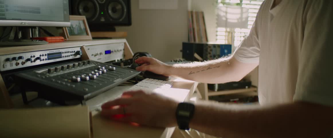 A man in front of a computer editing music