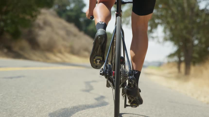 Cyclist drives a bicycle down a road