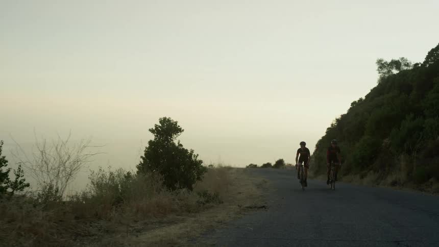 Two people cycling on a road
