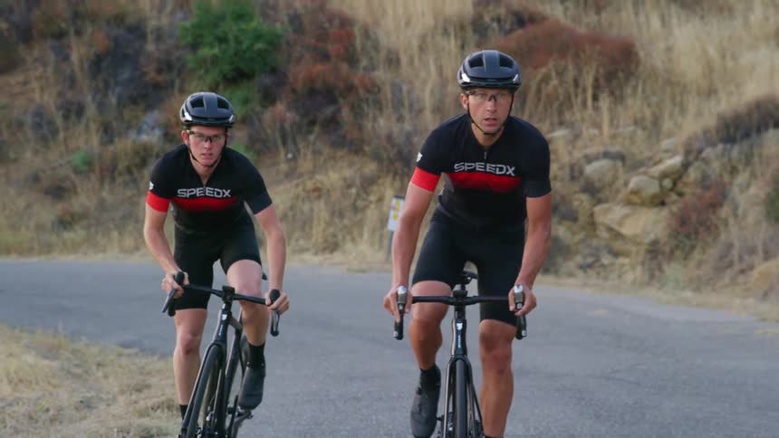 Cyclists with cycling helmet and cycling jersey ride bicycles on a mountain road