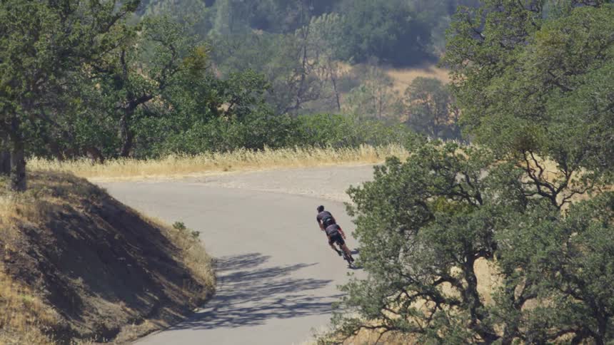 Two cyclists ride bicycles on a road