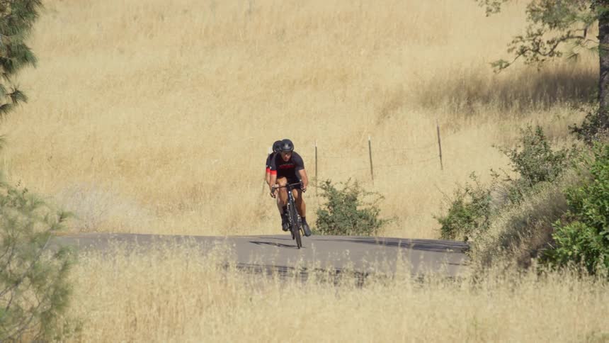 Two men ride their bikes around the trail