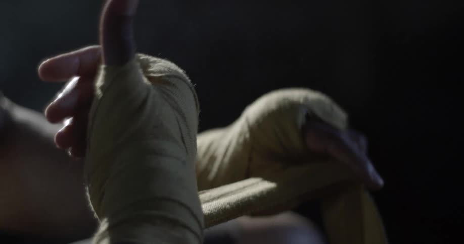 A person is taping up his hands with cloth