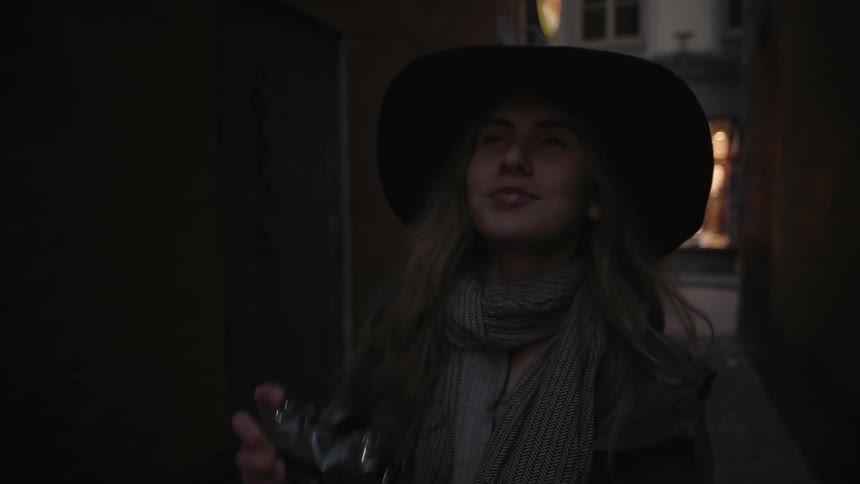 A woman is outside taking photographs in an alley