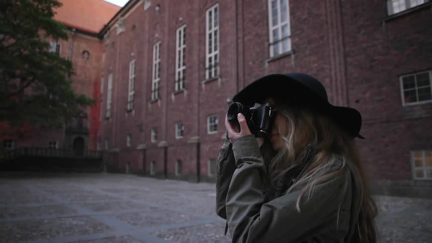 A woman taking photographs in a courtyard