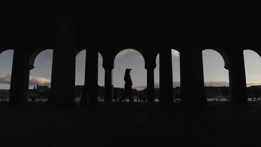 A woman in a cowboy hat walks through a monument