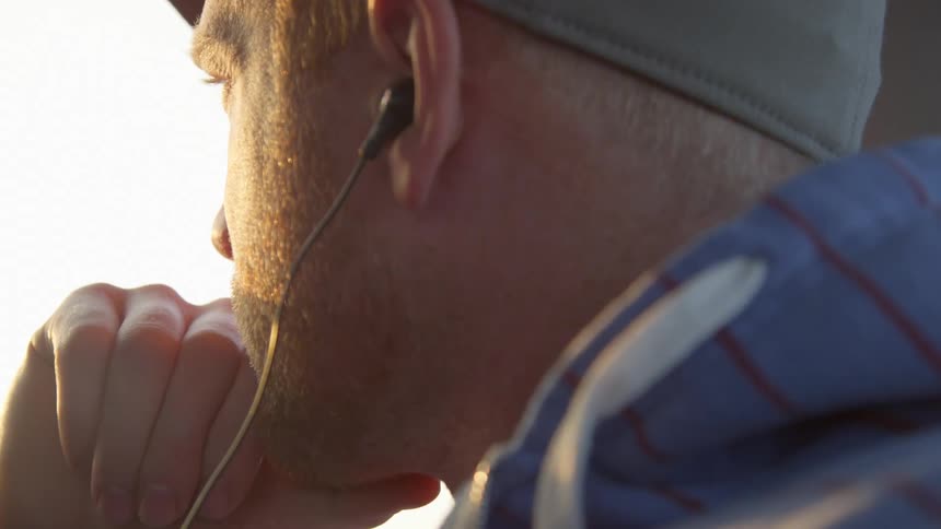 A man listens to music as he looks out the window of a moving vehicle
