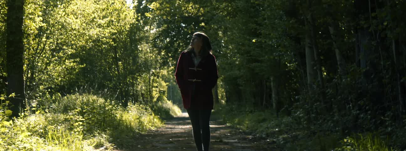 Young woman walking on a dirt path in the forest