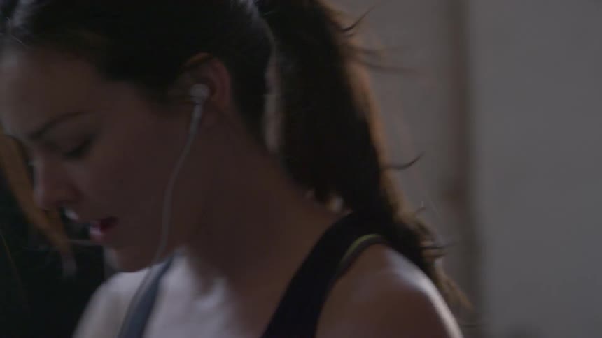 A woman wearing gloves is in a gym punching a punching bag