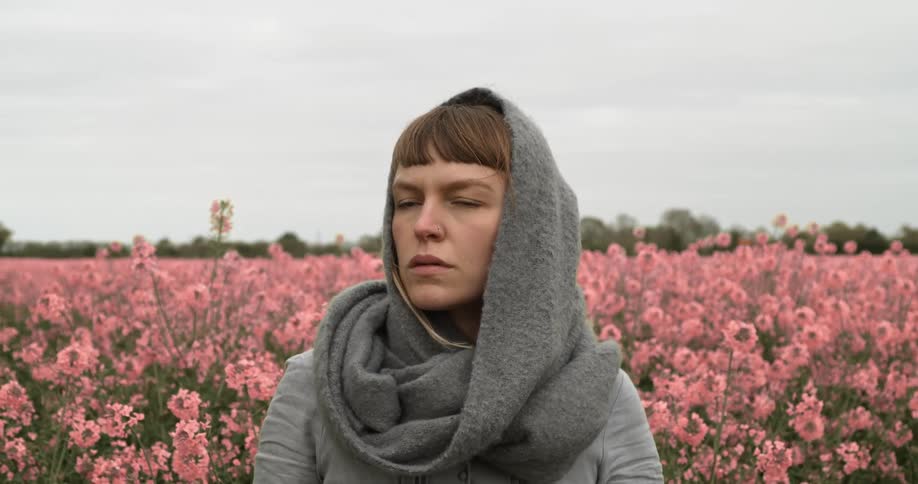 Woman posing in a field of pink flowers in the country