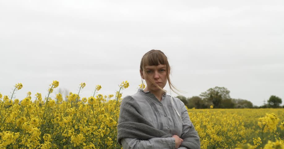 A young woman stands in a field of flowers