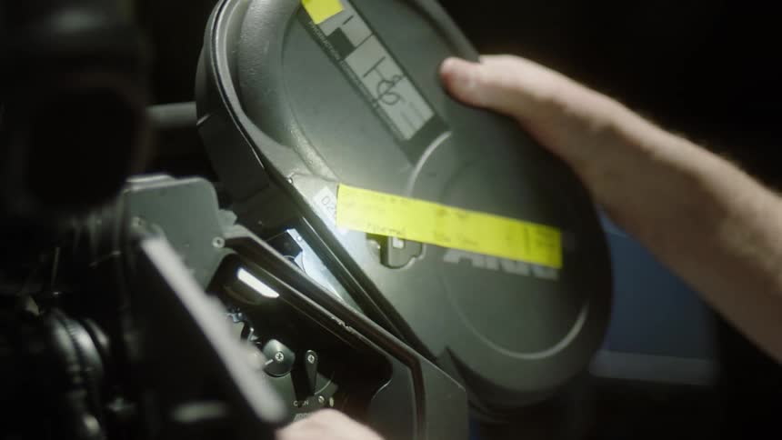 Man loads a camera with a roll of film