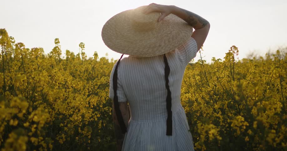 A woman walks through a field of flowers
