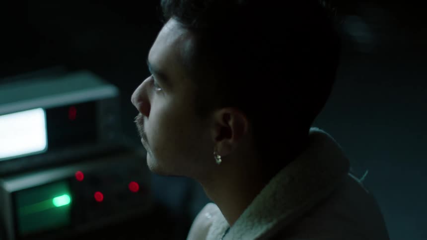A man is working at a machine in the dark