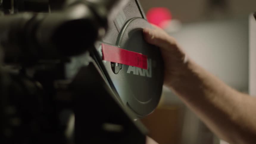 A man attaches a film real to a professional movie camera