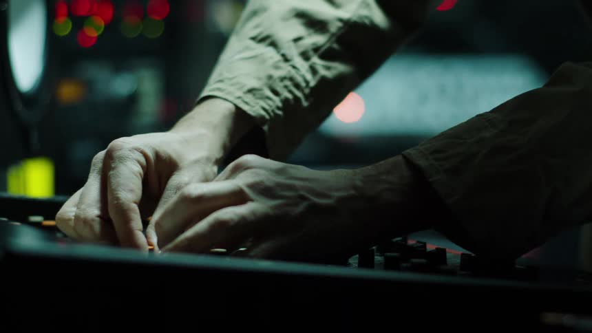 A person is turning knobs on a panel
