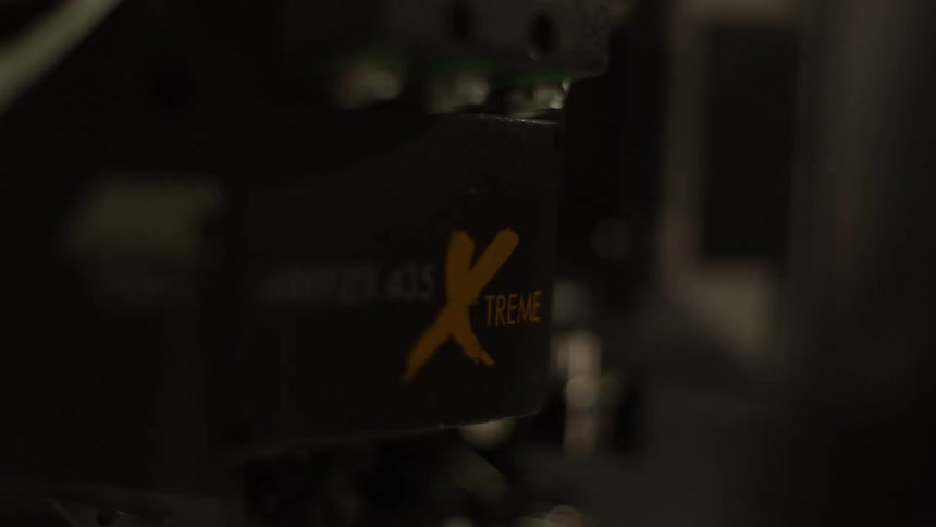 A film camera turns to film a person walking by