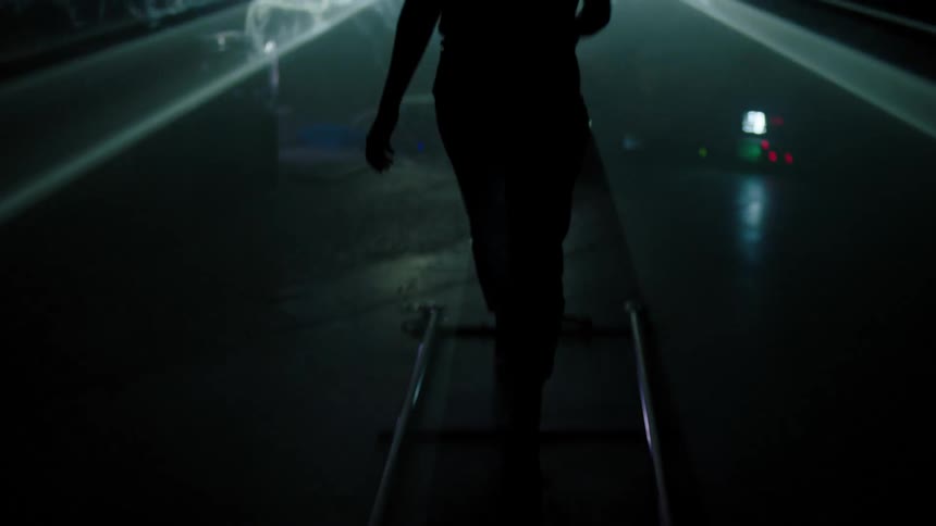 A model walks up and down a runway as lights flash