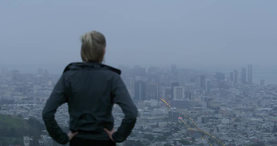 A woman stands and looks at the city skyline