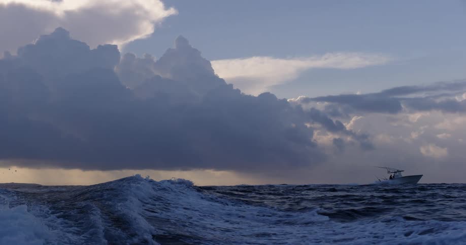 Boats in the ocean at sunset