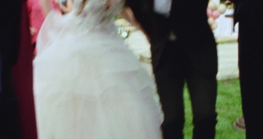 A bride and groom running past guests