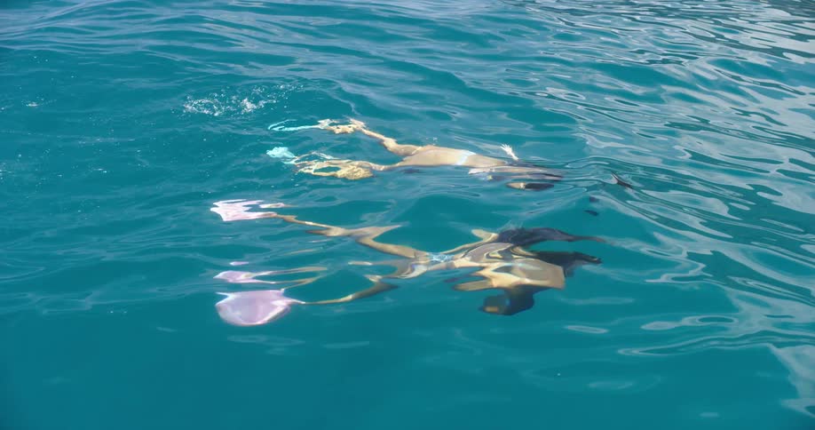 Two girls swimming underwater