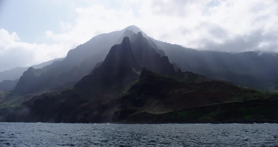 Mountains sit next to the rough ocean waters