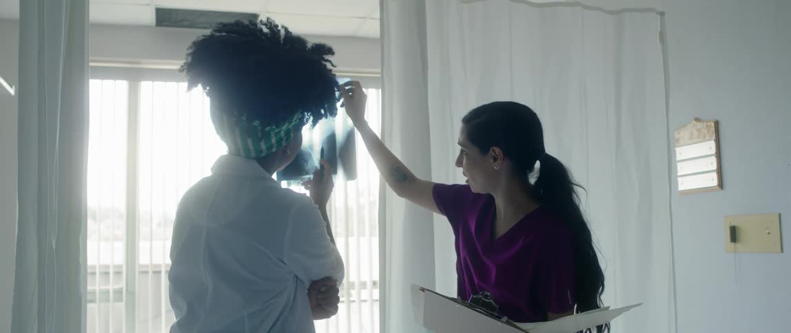 A doctor shows a patient her xray