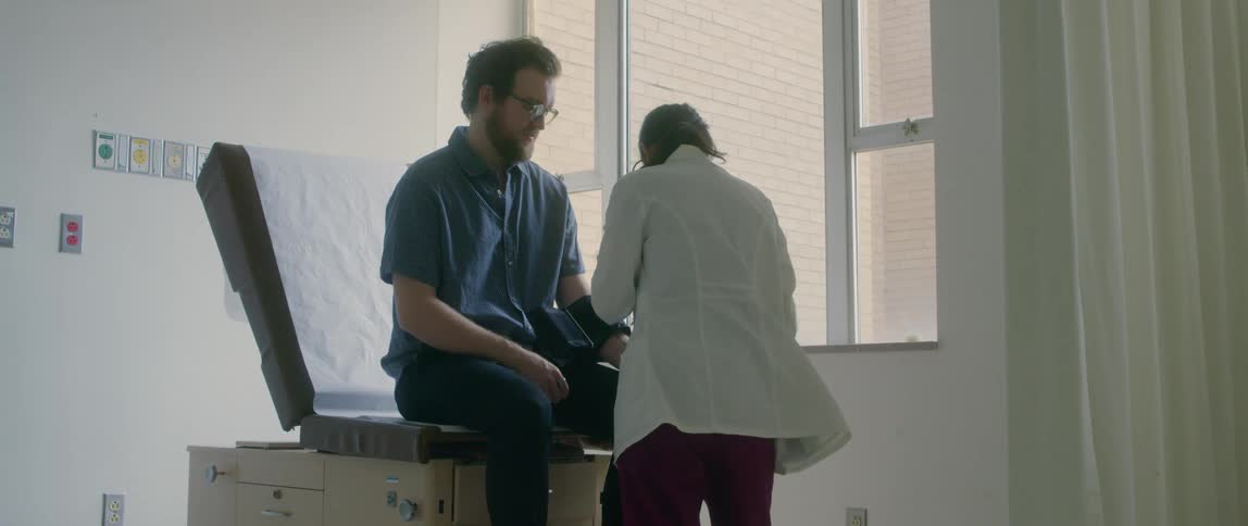 Doctor examines a patient sitting in an examination table on a clinic