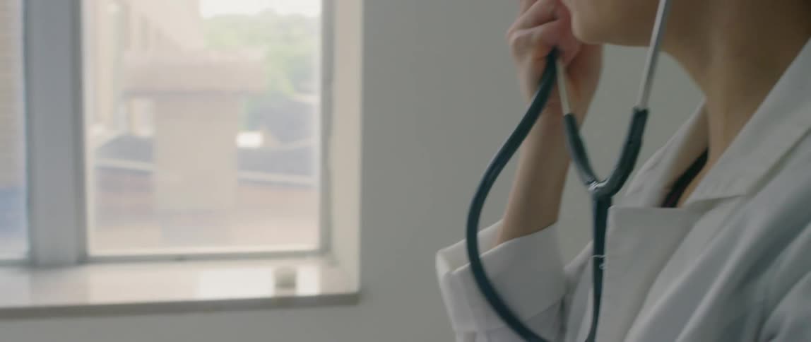 A man is getting his blood pressure checked at a doctors office and the doctor smiles after finishing