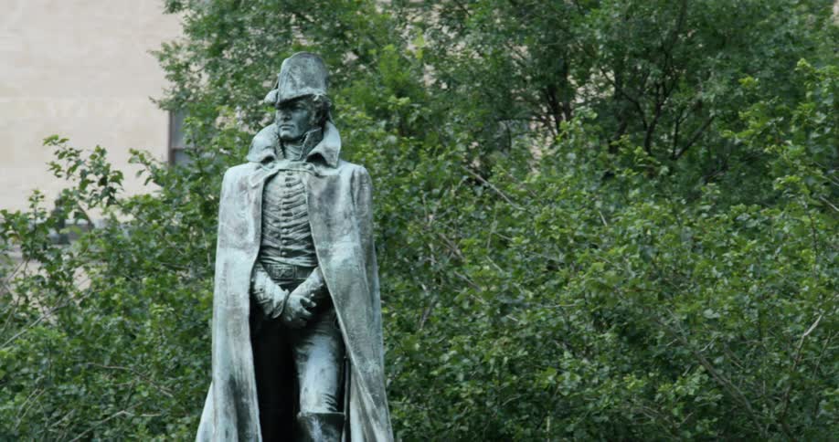 A statue stands in a park in the city