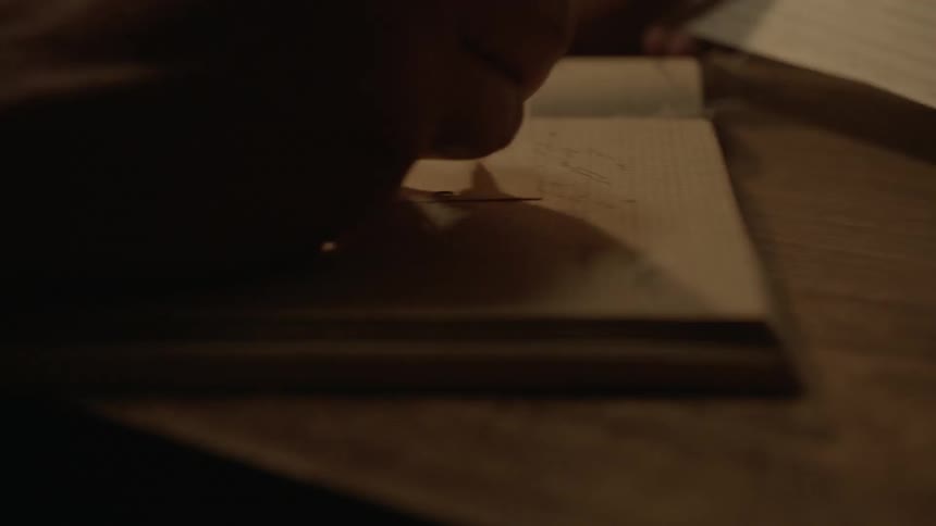 A person begins writing in a notebook