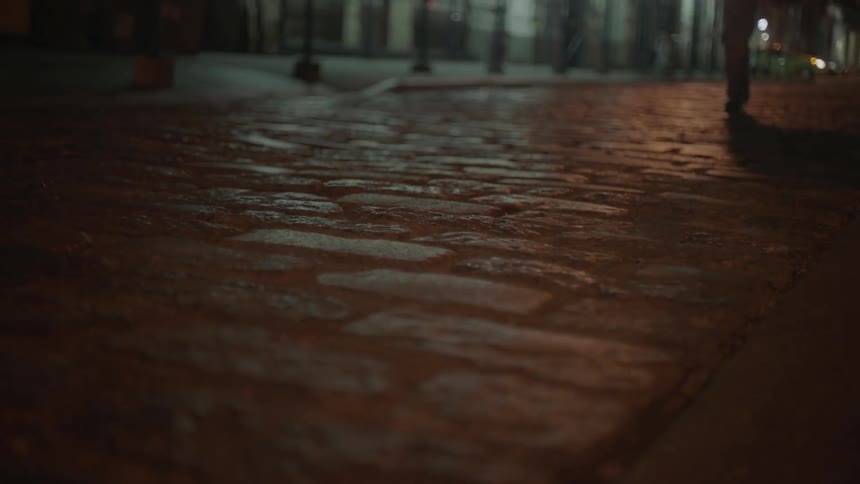 The feet of a man and woman running down a cobblestone street