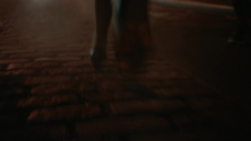 Two people are running along a street at night