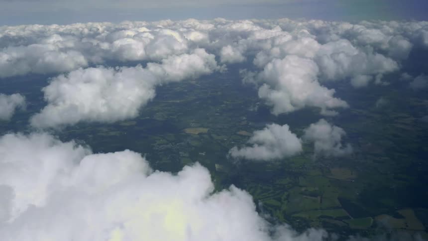 Aerial footage of terrain taken from above clouds