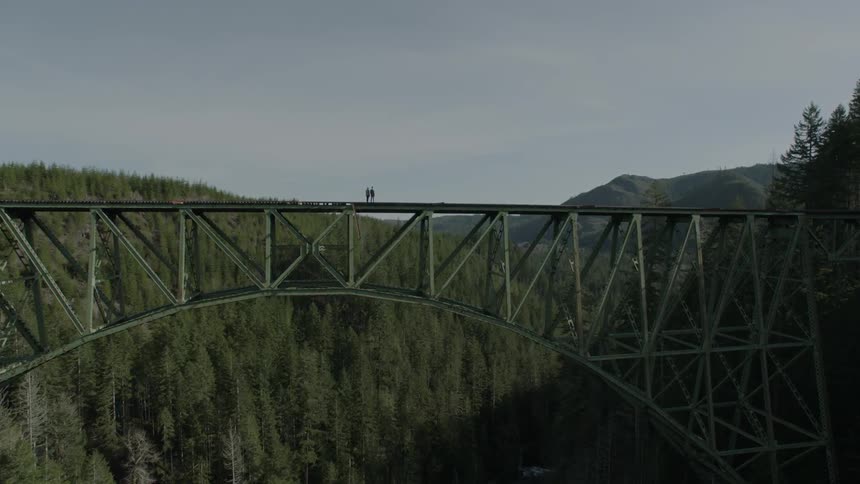 Two people are on a bridge on a cloudy day