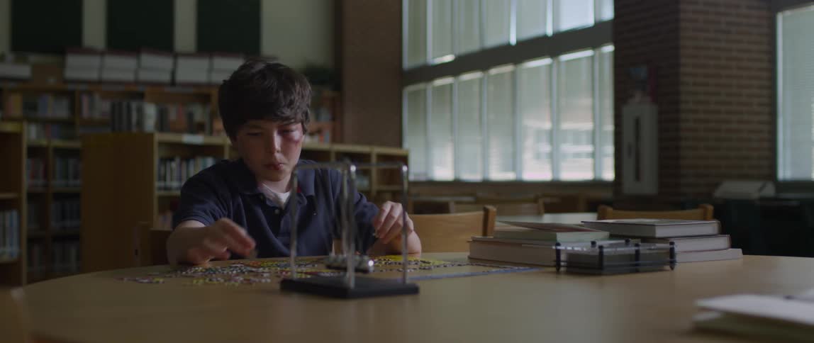 Boy sits in library after school