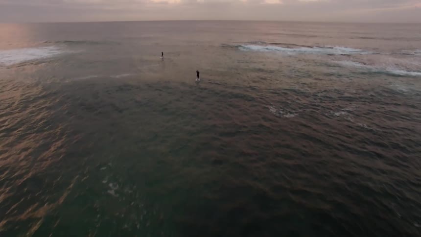 People paddle boarding out on ocean water