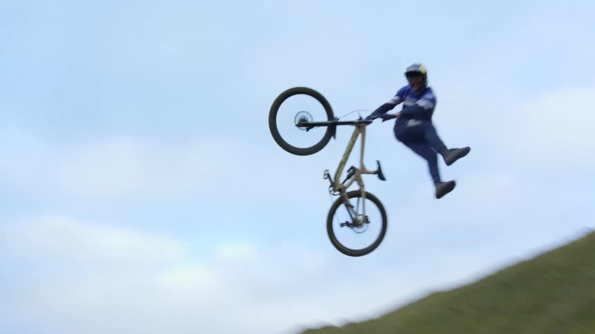 A young man performs tricks on a bike
