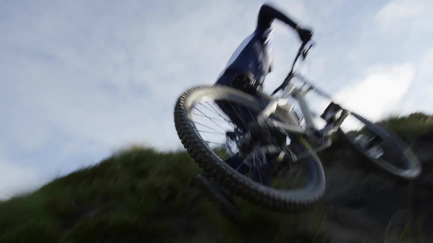A male carries his bike up a hill