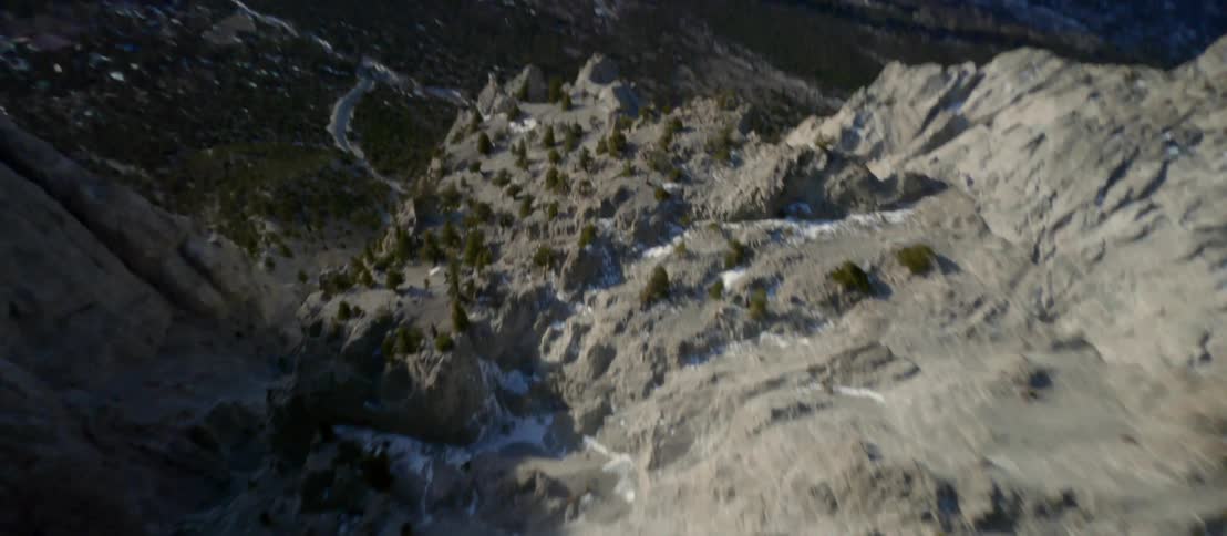A river winds through trees at the bottom of a canyon