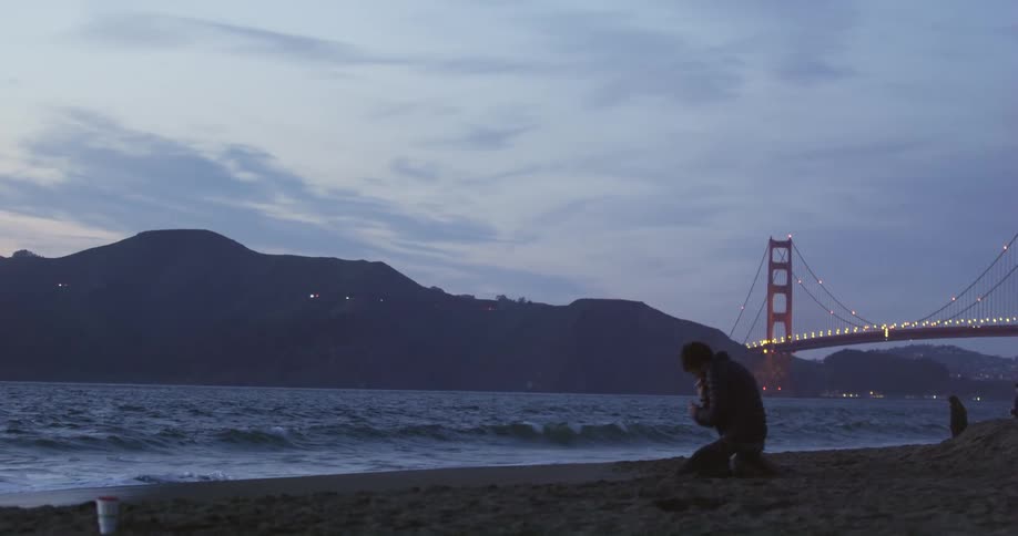 A man lights a cigarette on the shore