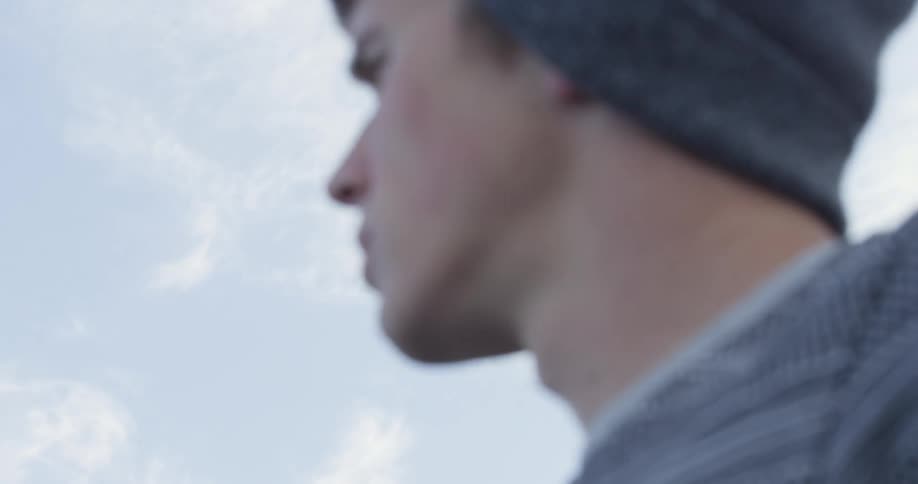 Man wearing knit hat gets out of car and walks away