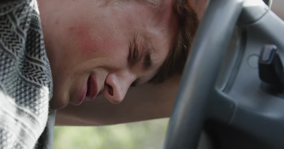 A man is crying in his car