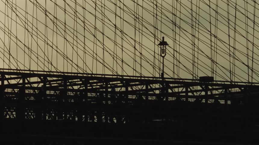 Cars and pedestrians over the brooklyn bridge in new york at sunset