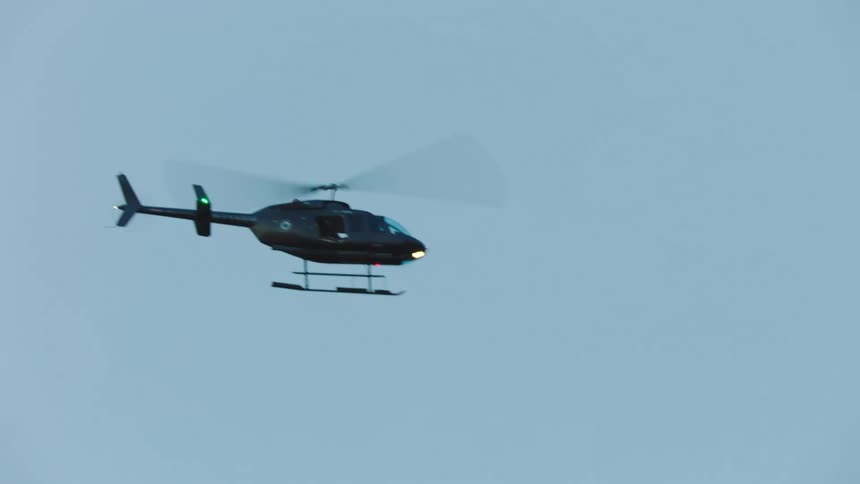 A helicopter flying over a bridge