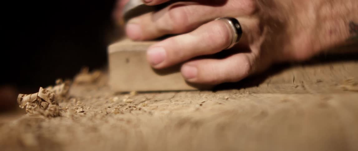 A man sands wood