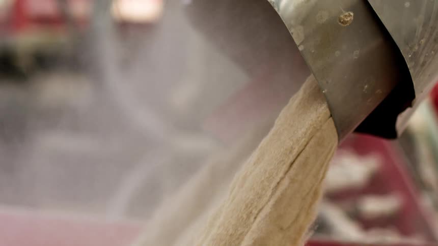 A machine pours grain from a shoot