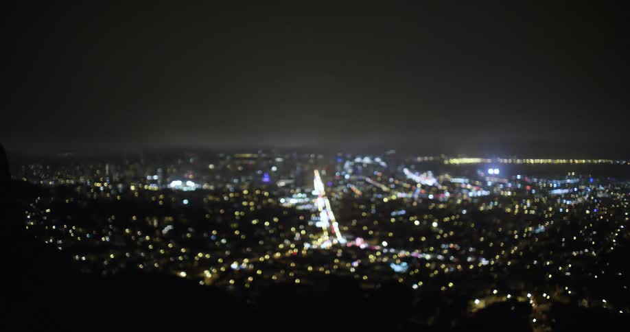 A city skyline and major road covered in lights at night