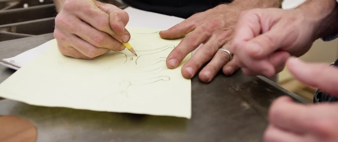 A person is drawing a design on a piece of paper